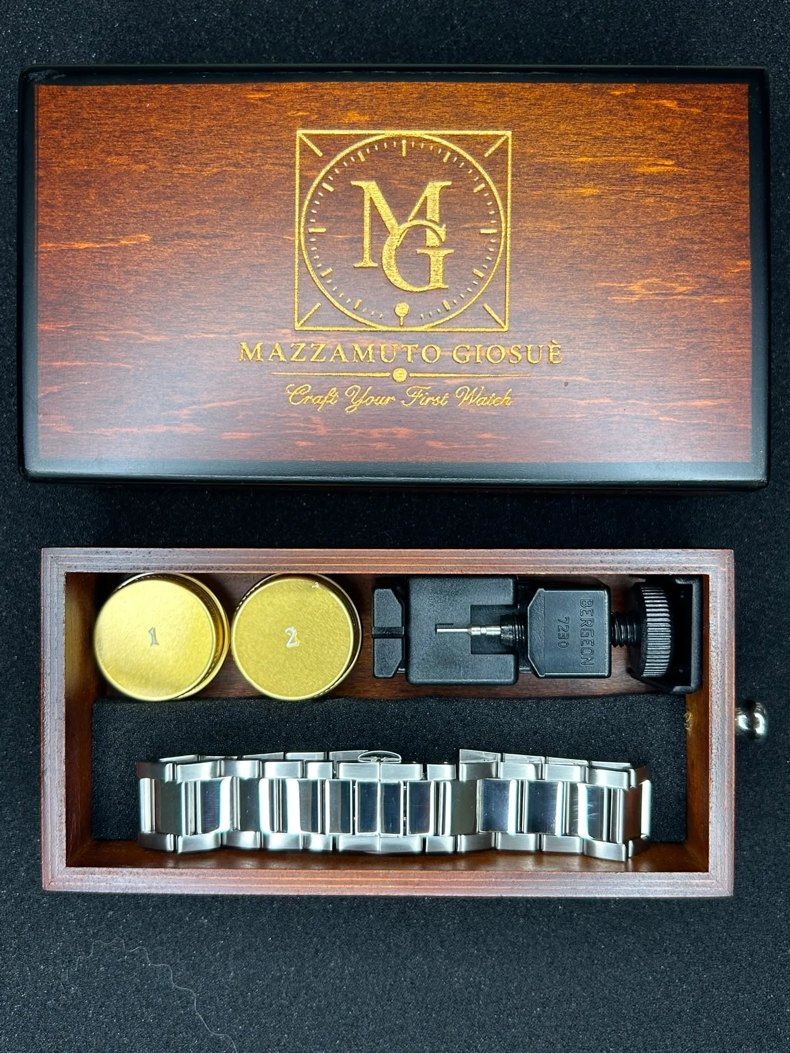 Le coffret ouvert, vu du dessus : le couvercle au monogramme et le compartiment où chaque élément est rangé à sa place.