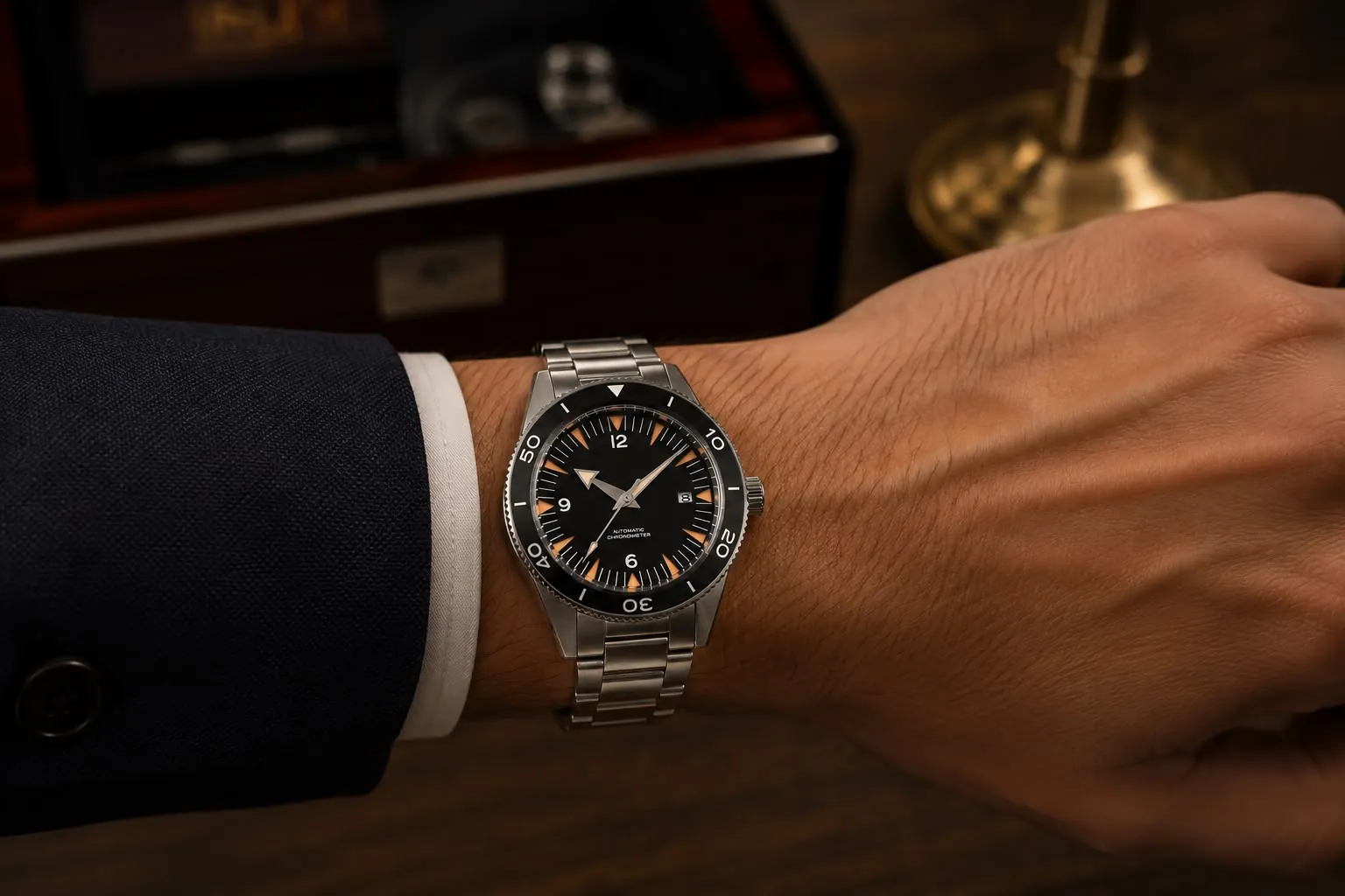 Une montre portée au poignet, avec une manchette blanche et une veste sombre.